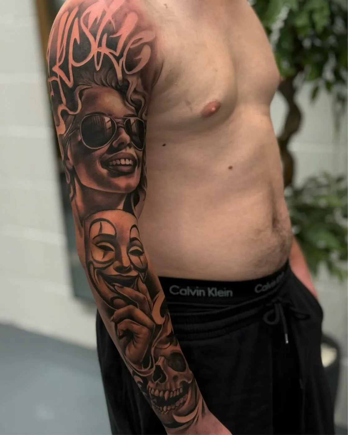 full arm sleeve with chicano payasa portrait, theatre mask and skull