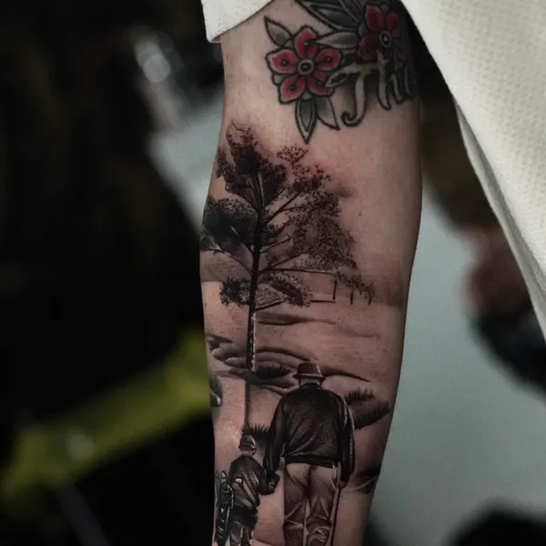 quiet black and grey countryside scene with a lone tree, worked into the upper arm