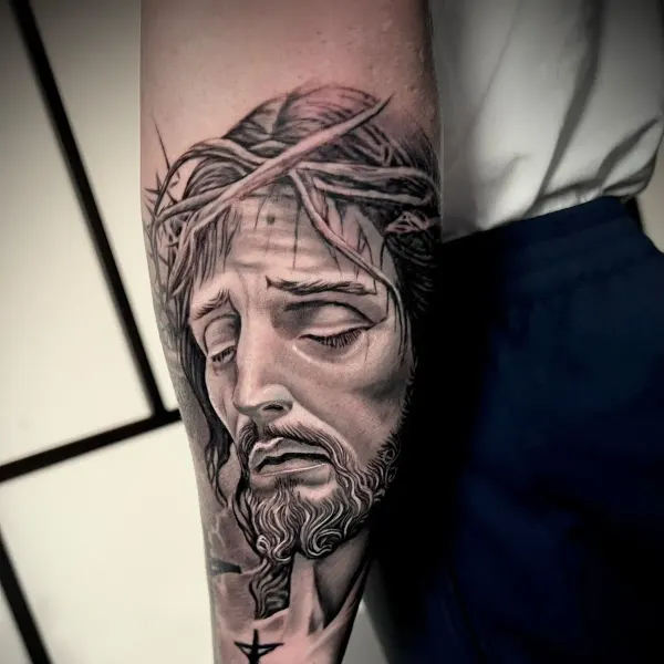 Black and grey religious portrait with crown of thorns, forearm tattoo by Raf at Shade Studio Peterborough