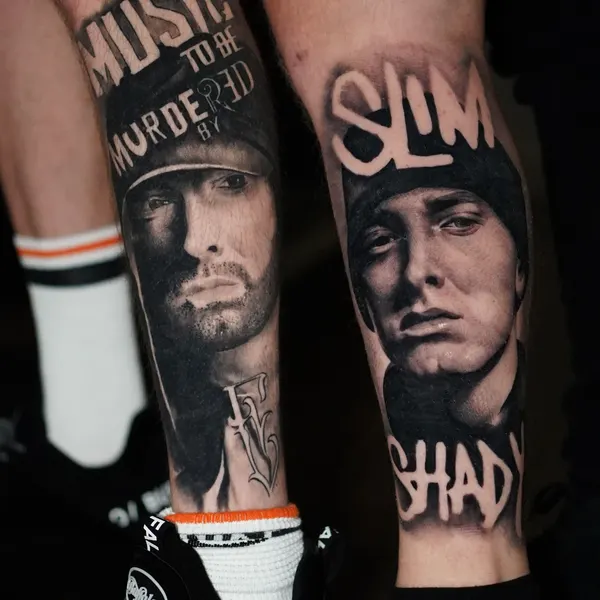 matching black and grey rapper portraits with lyric lettering, one on each calf