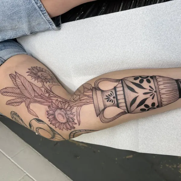 Sunflowers in a Greek urn, blackwork and stipple shaded leg tattoo by Lana at Shade Studio Peterborough