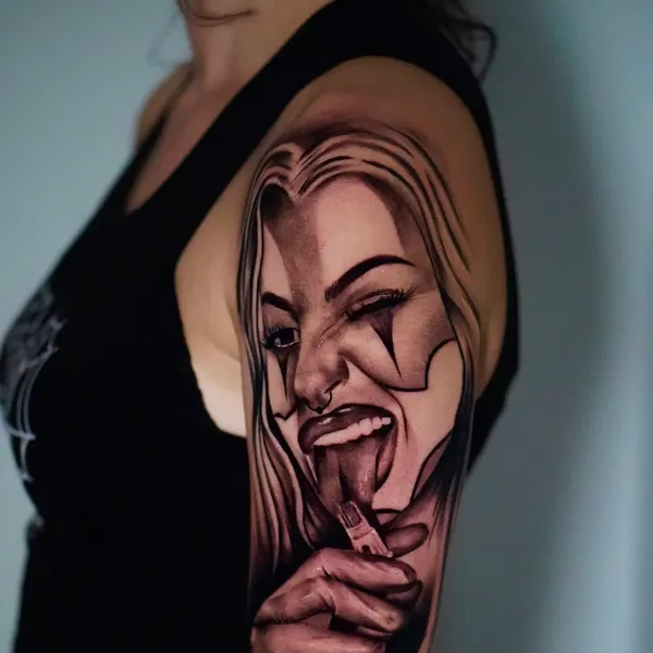 chicano style payasa portrait with tongue out, tattooed by jason across the shoulder