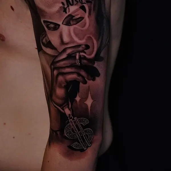 chicano forearm piece: a masked face smoking above a dollar sign and stars