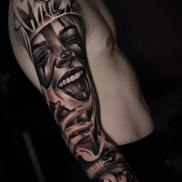 chicano theatre mask laughing above a skull, worked into an arm sleeve