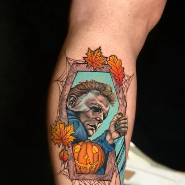 Michael Myers in a coffin frame with pumpkin and autumn leaves, colour calf tattoo by Karolina at Shade Studio Peterborough