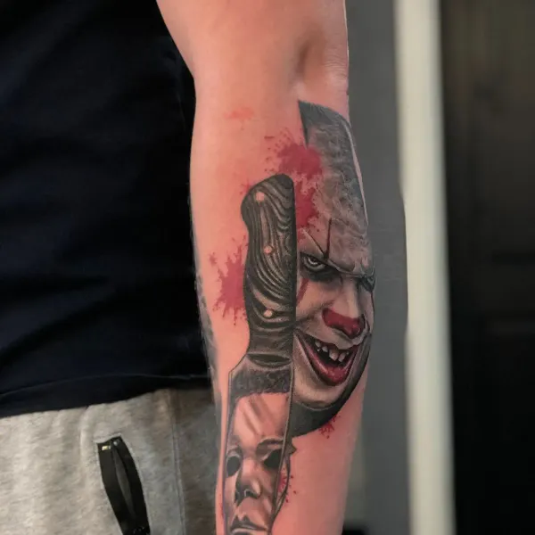 Pennywise and Michael Myers horror tattoo with knife and blood splatter, forearm by Raf at Shade Studio Peterborough