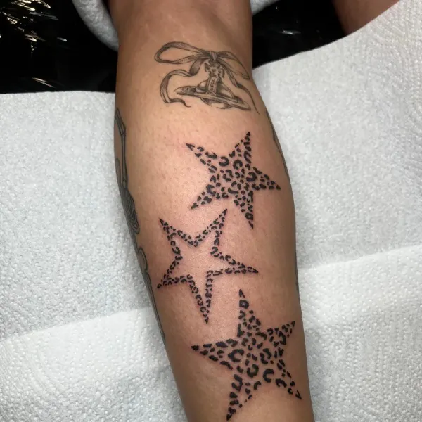Three leopard print stars, calf tattoo by Ashlee at Shade Studio Peterborough