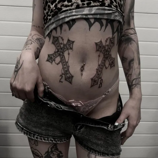 Matching ornamental crosses with chain and gem detail, stomach tattoos by Ashlee at Shade Studio Peterborough