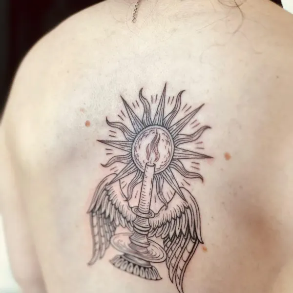 Winged candle with sunburst in illustrative linework, back tattoo by Hannah at Shade Studio Peterborough