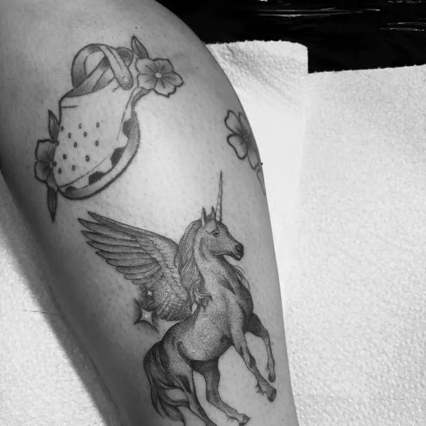 Winged unicorn in stipple shading, calf tattoo by Lana at Shade Studio Peterborough